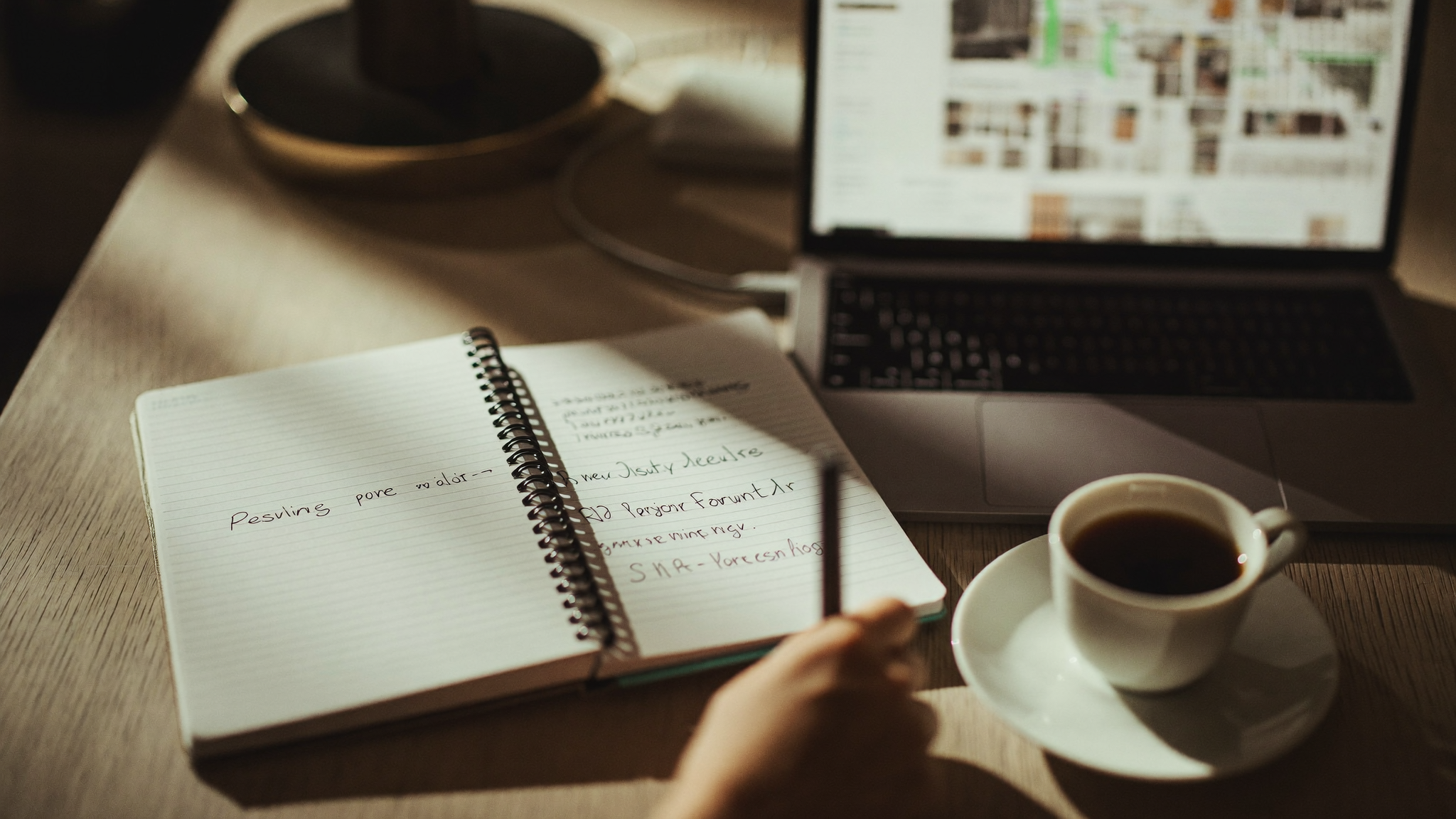 A real estate professional reviewing a client list and property records at a quiet office desk in late afternoon light